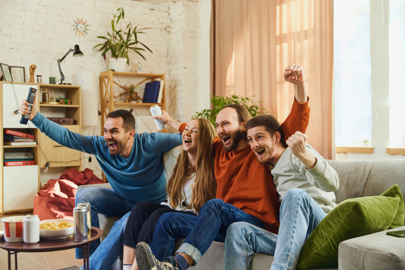 Group of happy and laughing young people watched decisive football match and favorite team winning victory. Concept of friendship, togetherness, TV program, online event, recreation, championship.