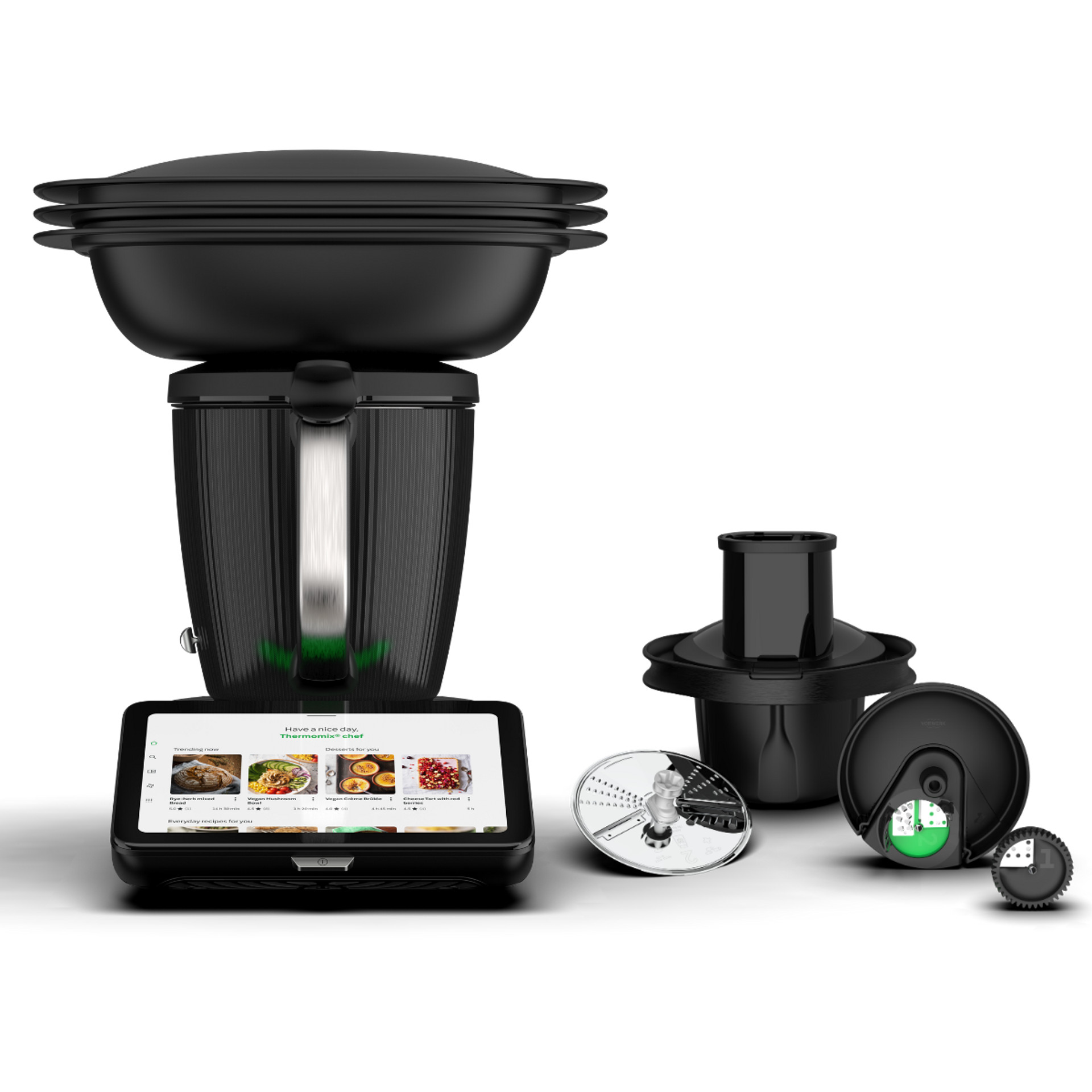 Thermomix® TM7 avec Varoma et Découpe-Minute+ avec ses disques, sur fond noir.
