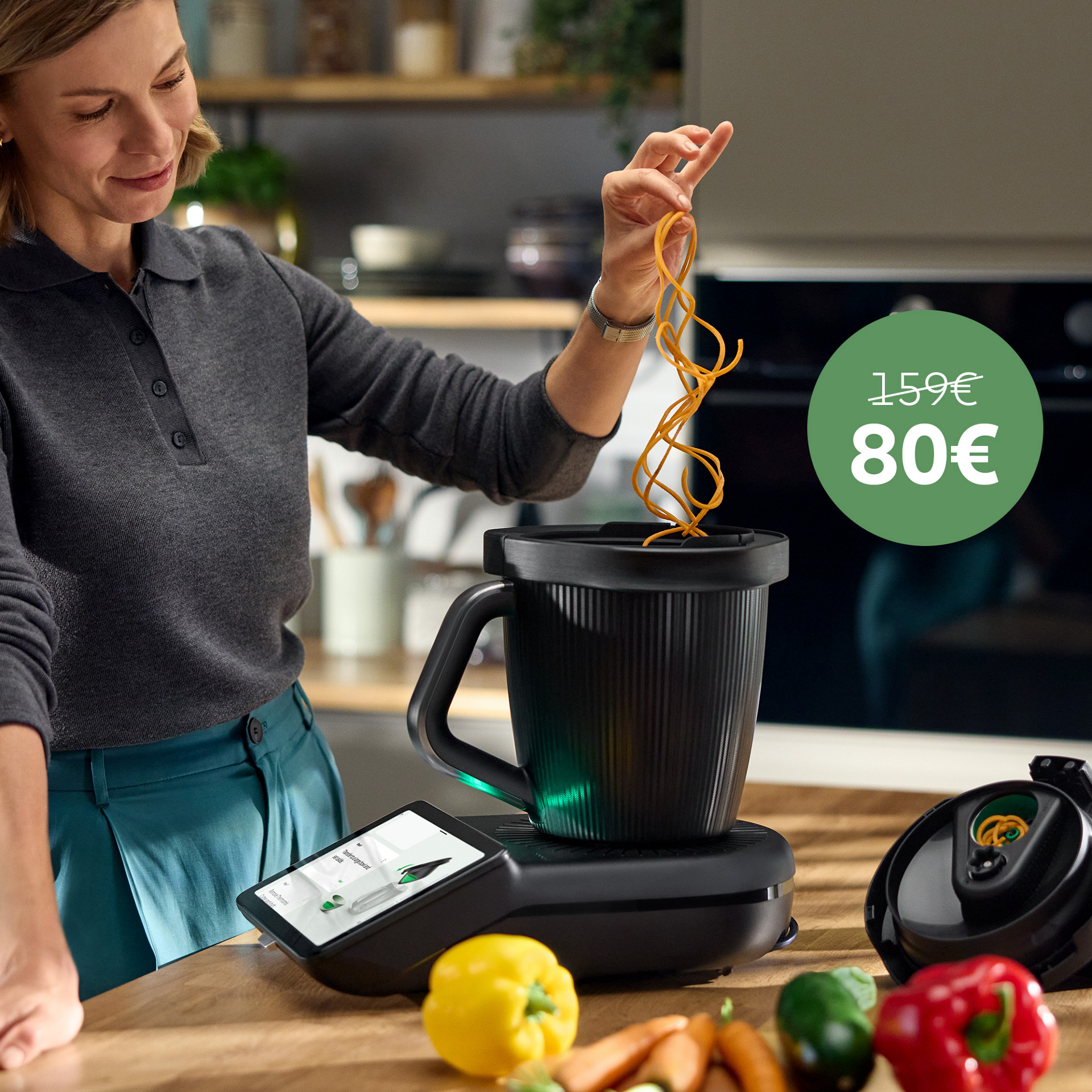 Femme utilisant Thermomix® TM7 avec Découpe-Minute+ dans la cuisine, légumes spiralés. Étiquette verte: 159 €, barré, 80 €.