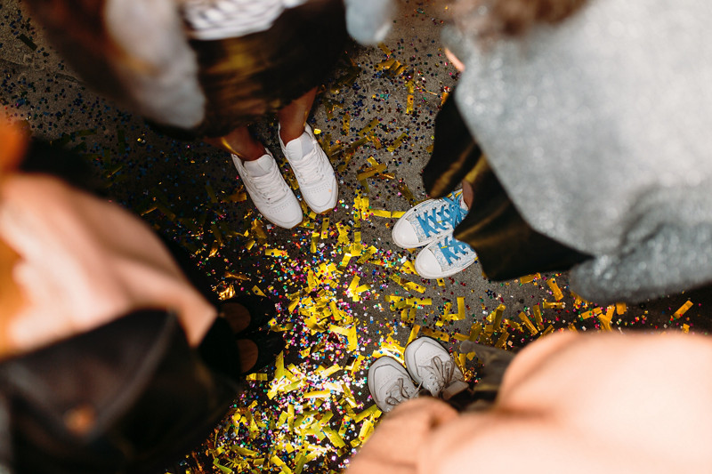 Vue de haut de quatre personnes faisant la fête avec un sol remplit de confettis