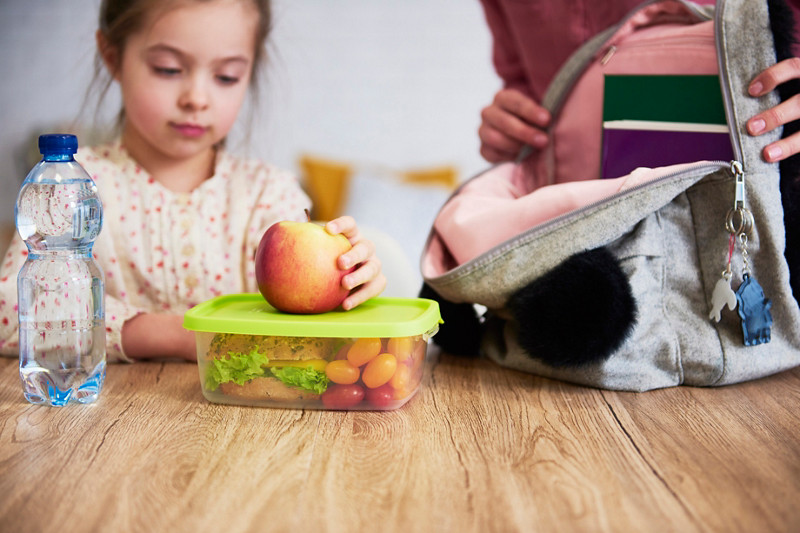 Fille qui vas à l'école avec sa lunch box 