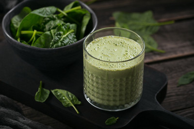 Verre de smoothie vert sain fait maison avec des épinards frais sur fond sombre. Concept de nourriture et de boisson, de régime et d'alimentation saine