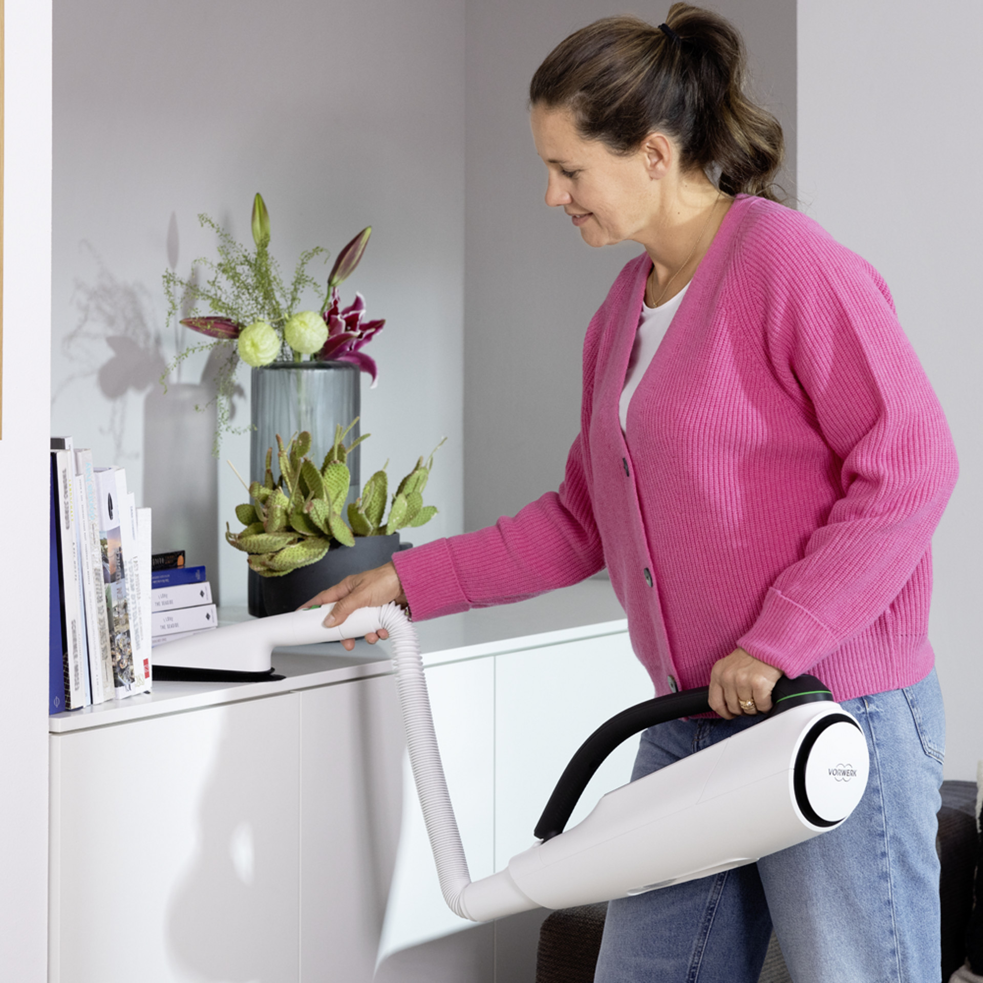 Nettoyage d'une étagère avec la Brosseur Textile Kobold PB7 dans un salon moderne.