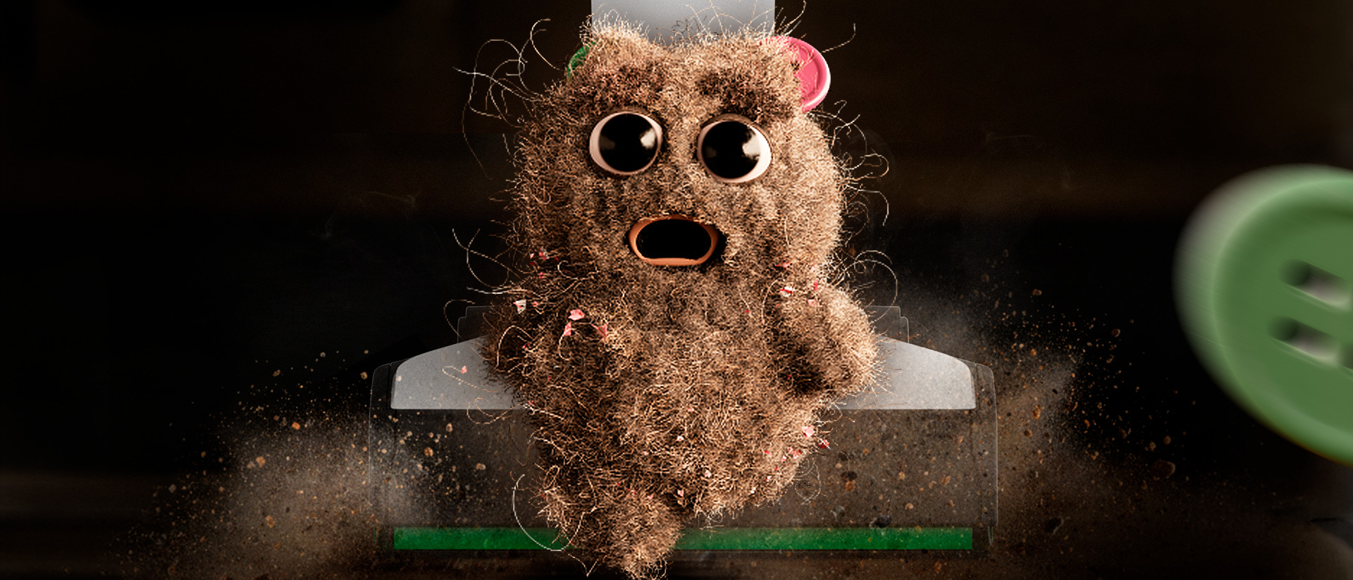 Boule de poussière animée au visage surpris sous la tête de nettoyage d’un aspirateur Kobold, entourée de poussière.