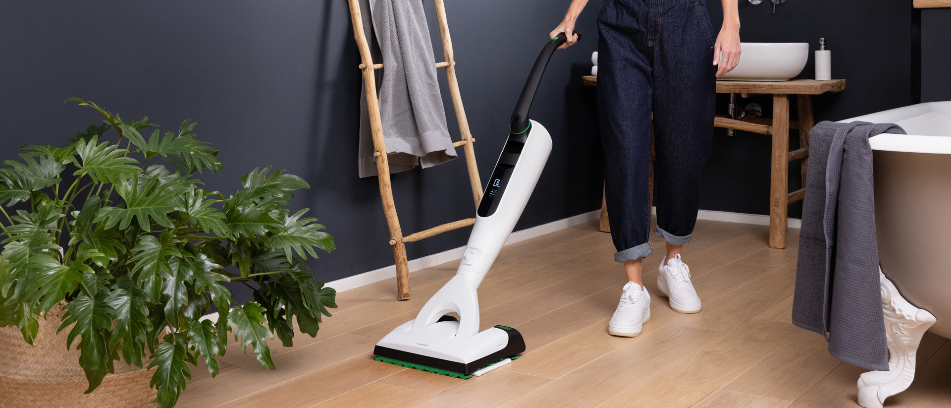 Personne nettoyant le sol de la salle de bain avec aspirateur laveur sans fil Kobold VK7 avec brosse DuoSpeed SP7.