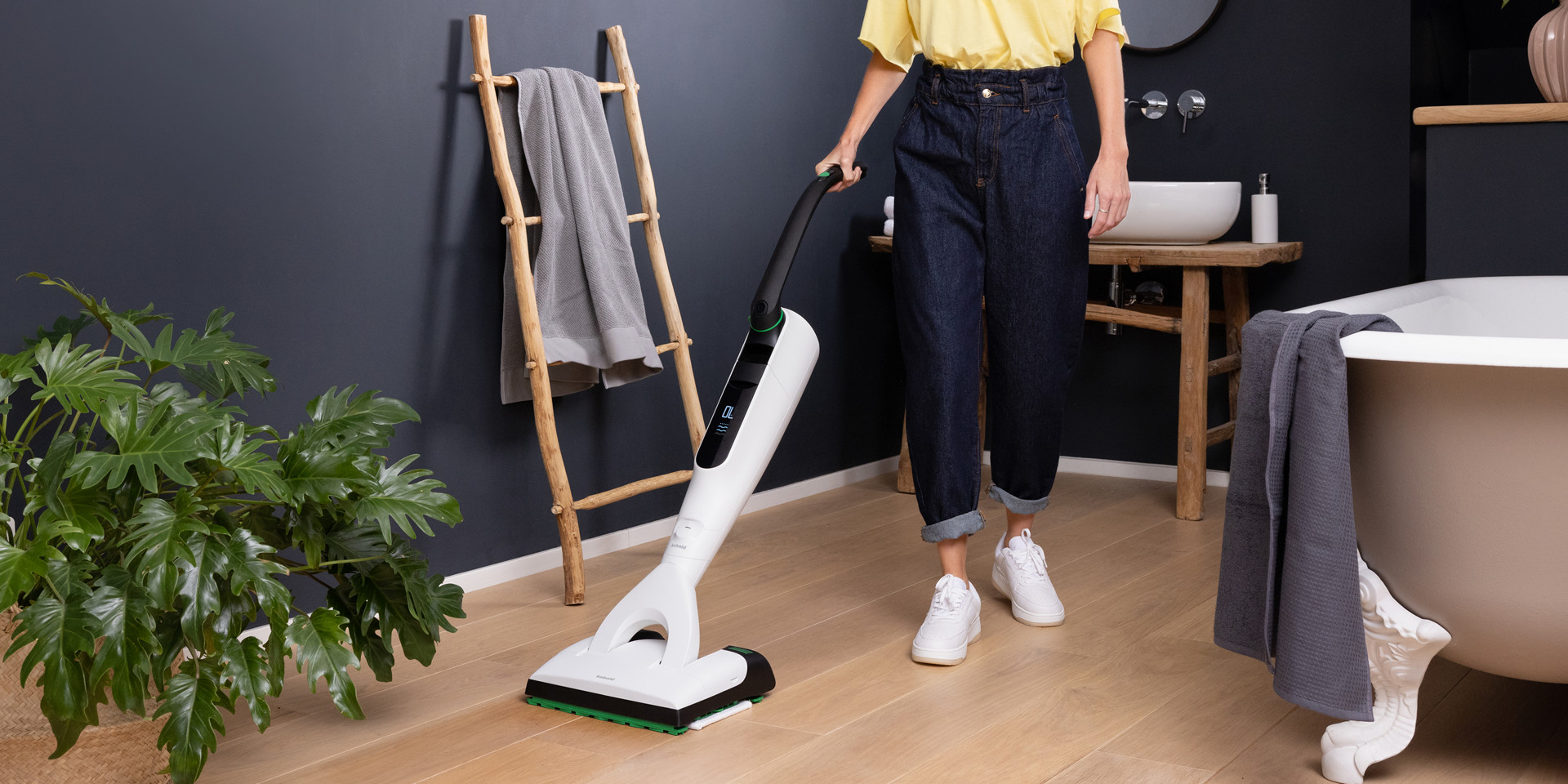 Personne nettoyant le sol de la salle de bain avec aspirateur laveur sans fil Kobold VK7 avec brosse DuoSpeed SP7.