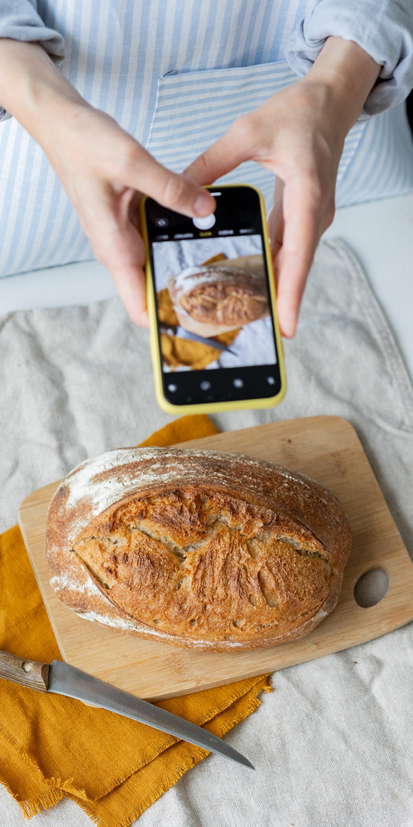Une femme prend en photo son pain fait maison