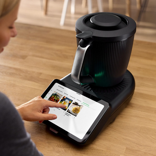 Une femme parcourt les recettes disponibles sur la plateforme de recette Cookidoo, sur l'écran de son Thermomix TM7