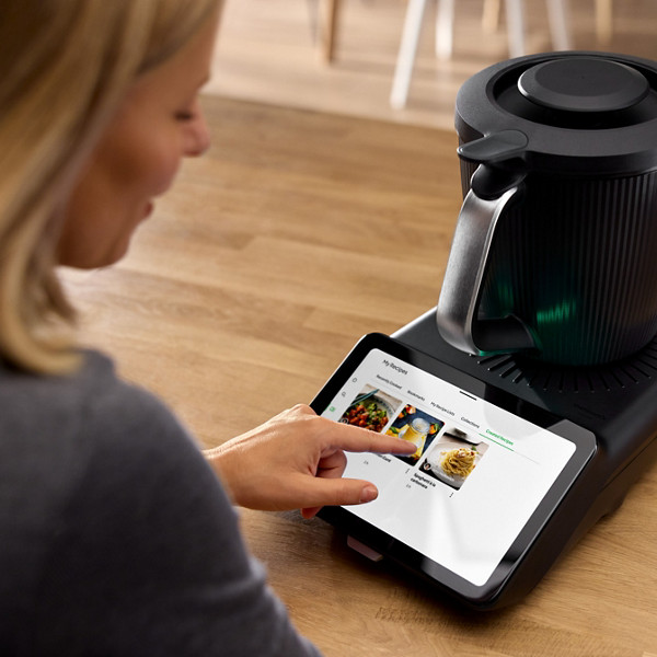 Une femme parcourt les recettes disponibles sur la plateforme de recette Cookidoo, sur l'écran de son Thermomix TM7