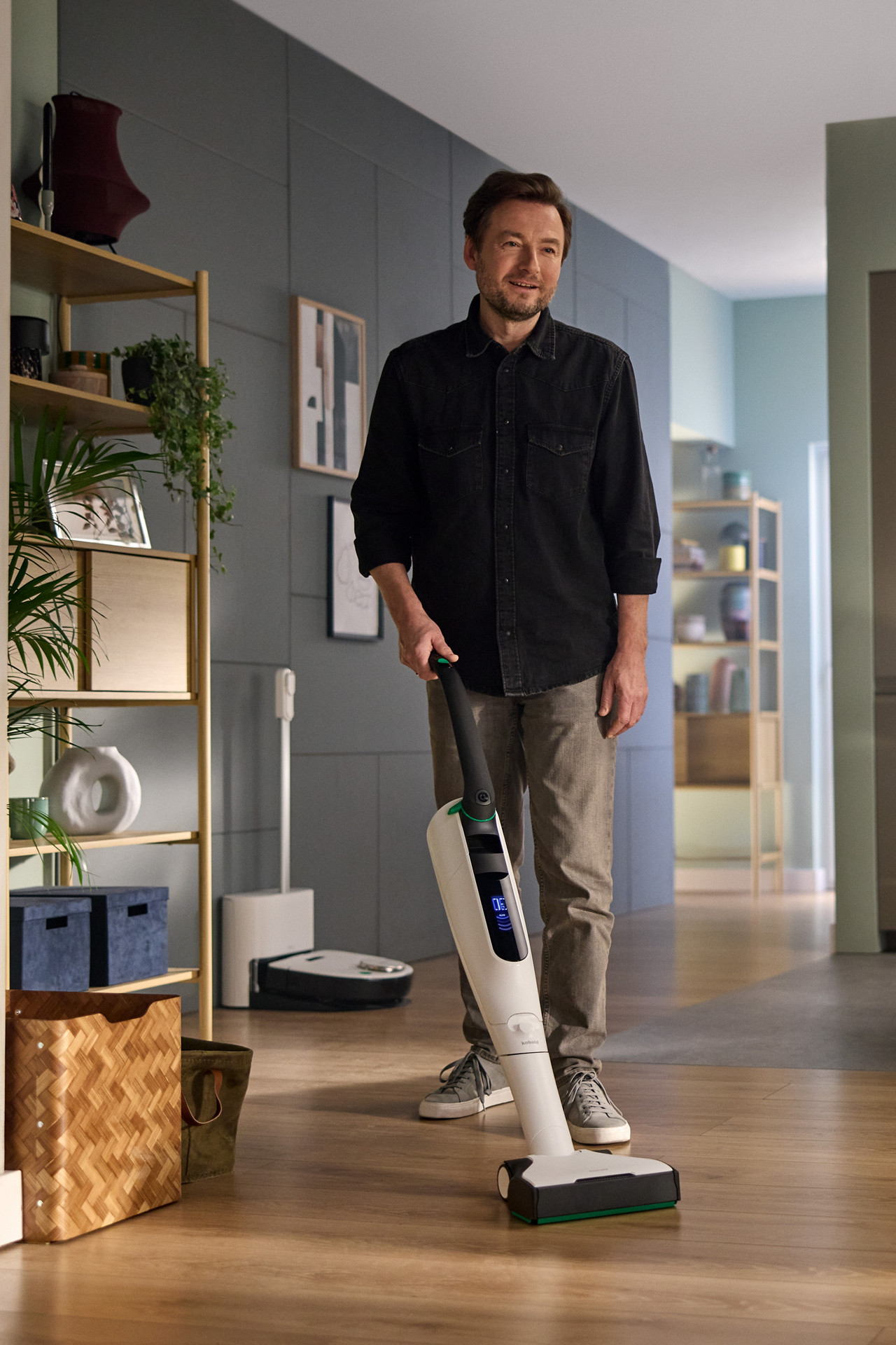 Une personne utilise l’aspirateur sans fil Kobold VK7, avec un Thermomix® TM6 sur le plan de travail de la cuisine.