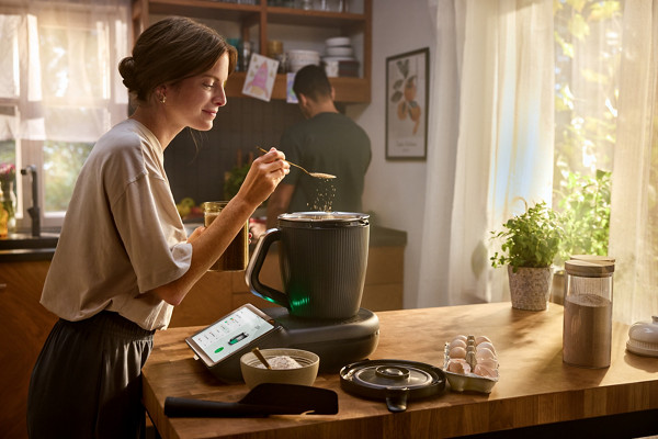 Une femme prépare une recette au Thermomix