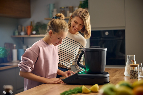 Une mère et sa fille préparent une recette avec le robot Thermomix