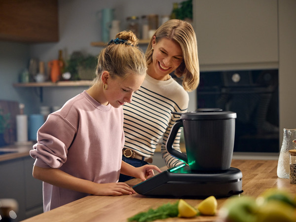 Une mère et sa fille préparent un plat avec le robot Thermomix TM7