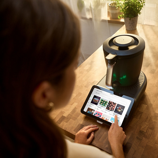 Une femme parcourt les recettes disponibles sur la plateforme de recette Cookidoo, sur l'écran de son Thermomix TM7