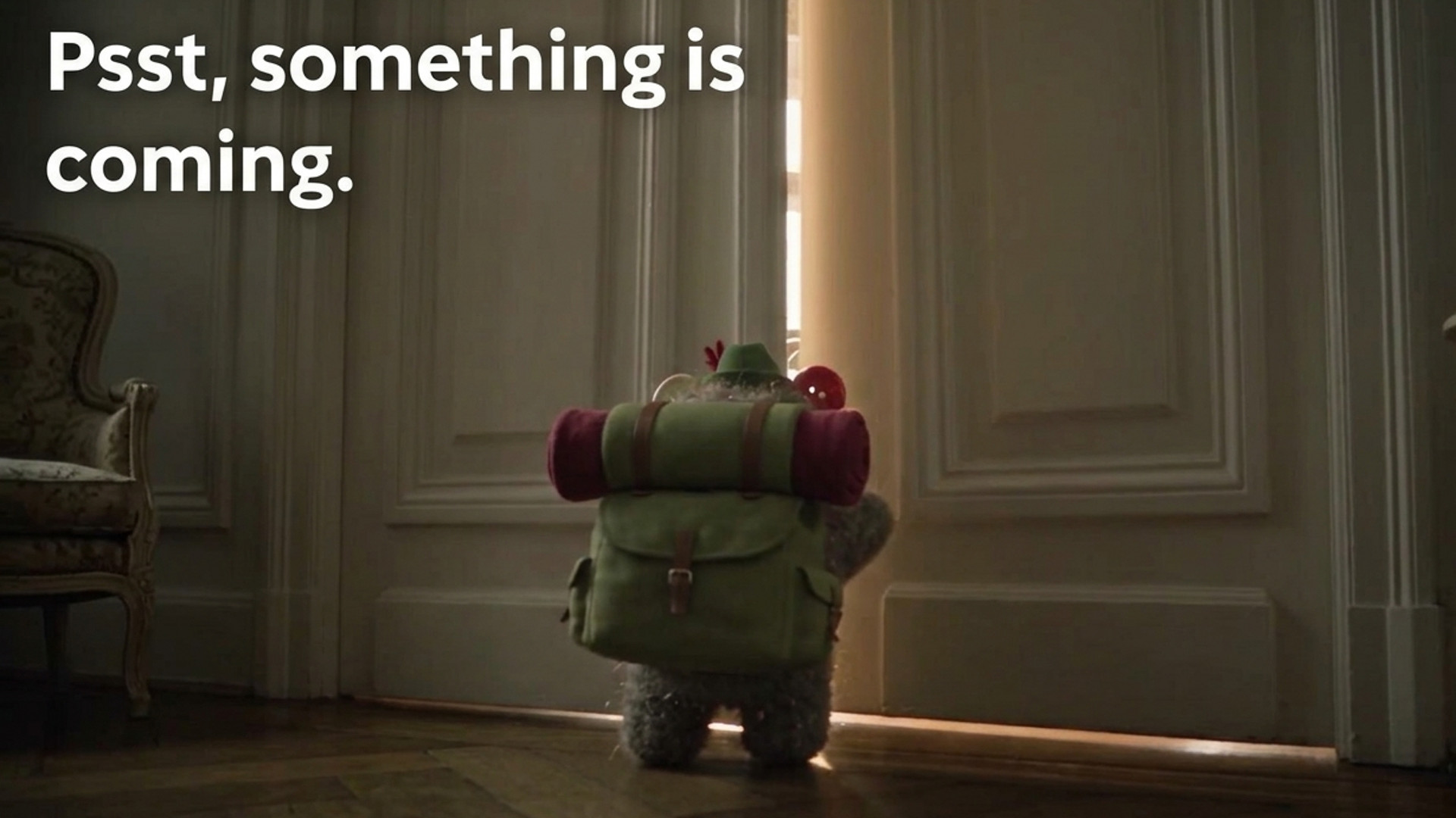 Fluffy toy with backpack stands at a slightly open door, text reads "Psst, something is coming."