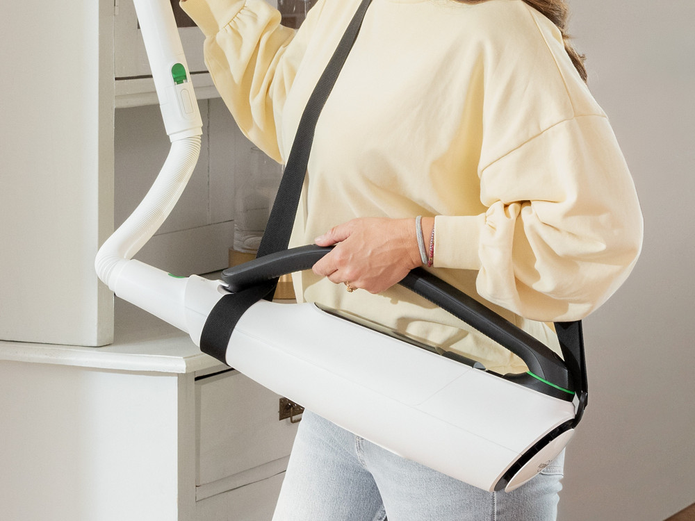 Frau saugt mit Kobold Schultergurt am Akku-Staubsauger