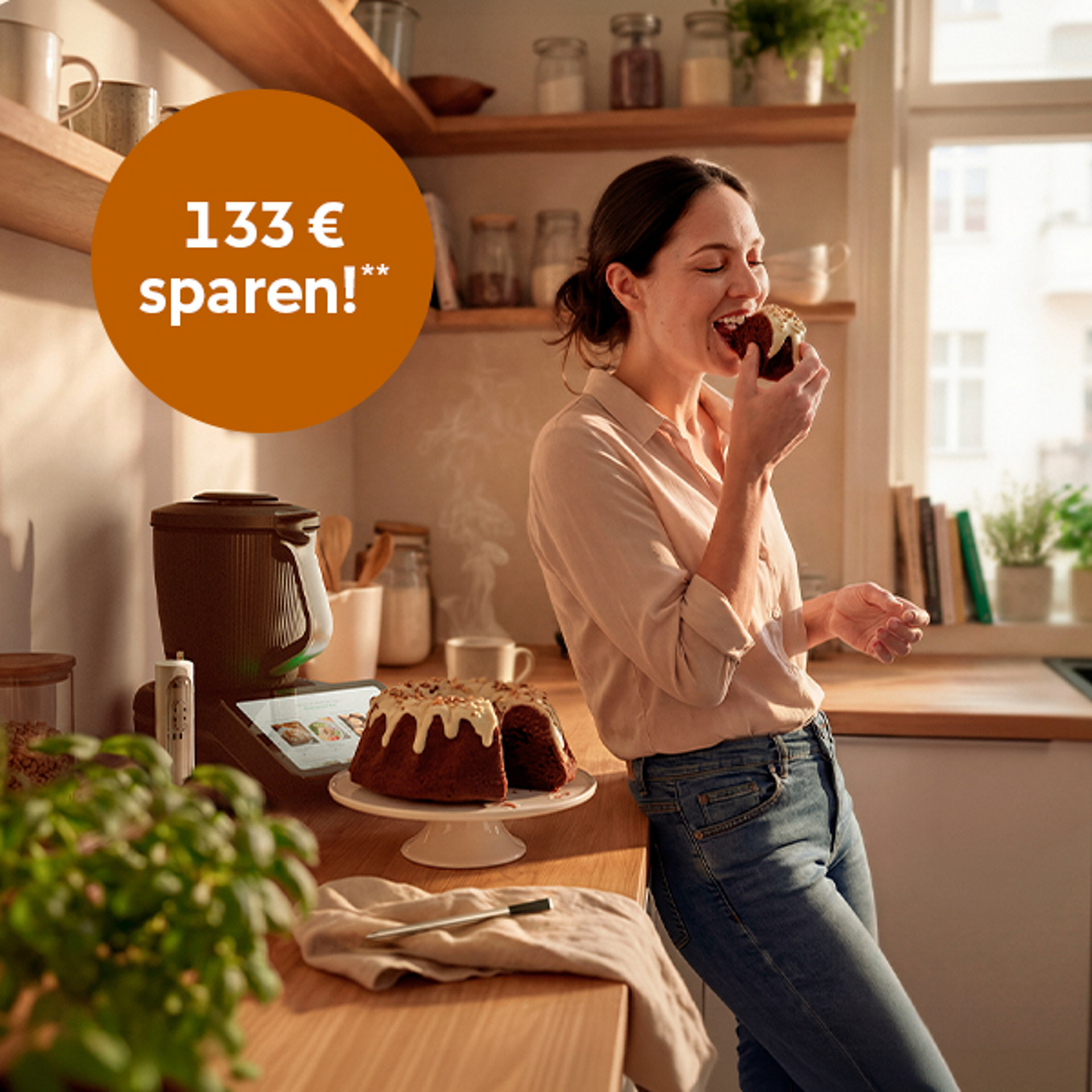 Frau in einer Küche mit Thermomix® TM7, Kuchen und Angebotsdetails zu 133 € Ersparnis. Text hebt Aktionszeitraum hervor.