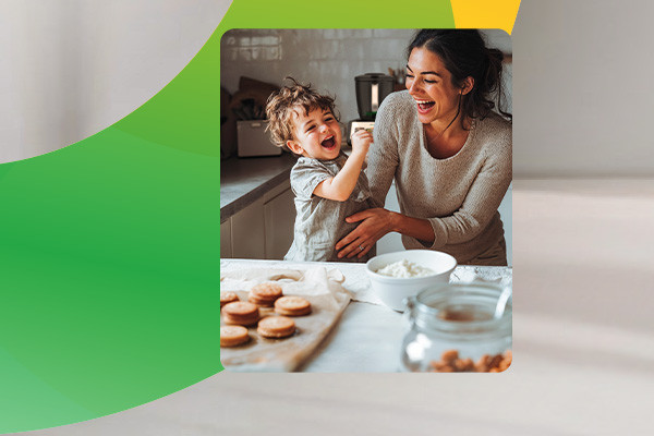 Lachende Frau mit Kind in der Küche beim Plätzchenbacken