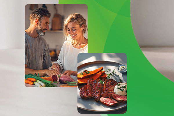 Paar in der Küche, daneben ein Teller mit Fleischgericht