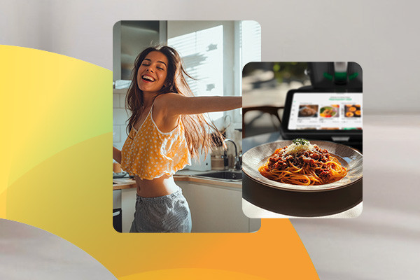 Tanzende Frau in Küche neben Teller mit Spaghetti- Gericht