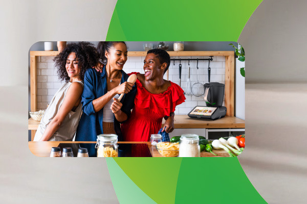 Drei lachende Frauen in der Küche, im Hintergrund der Thermomix