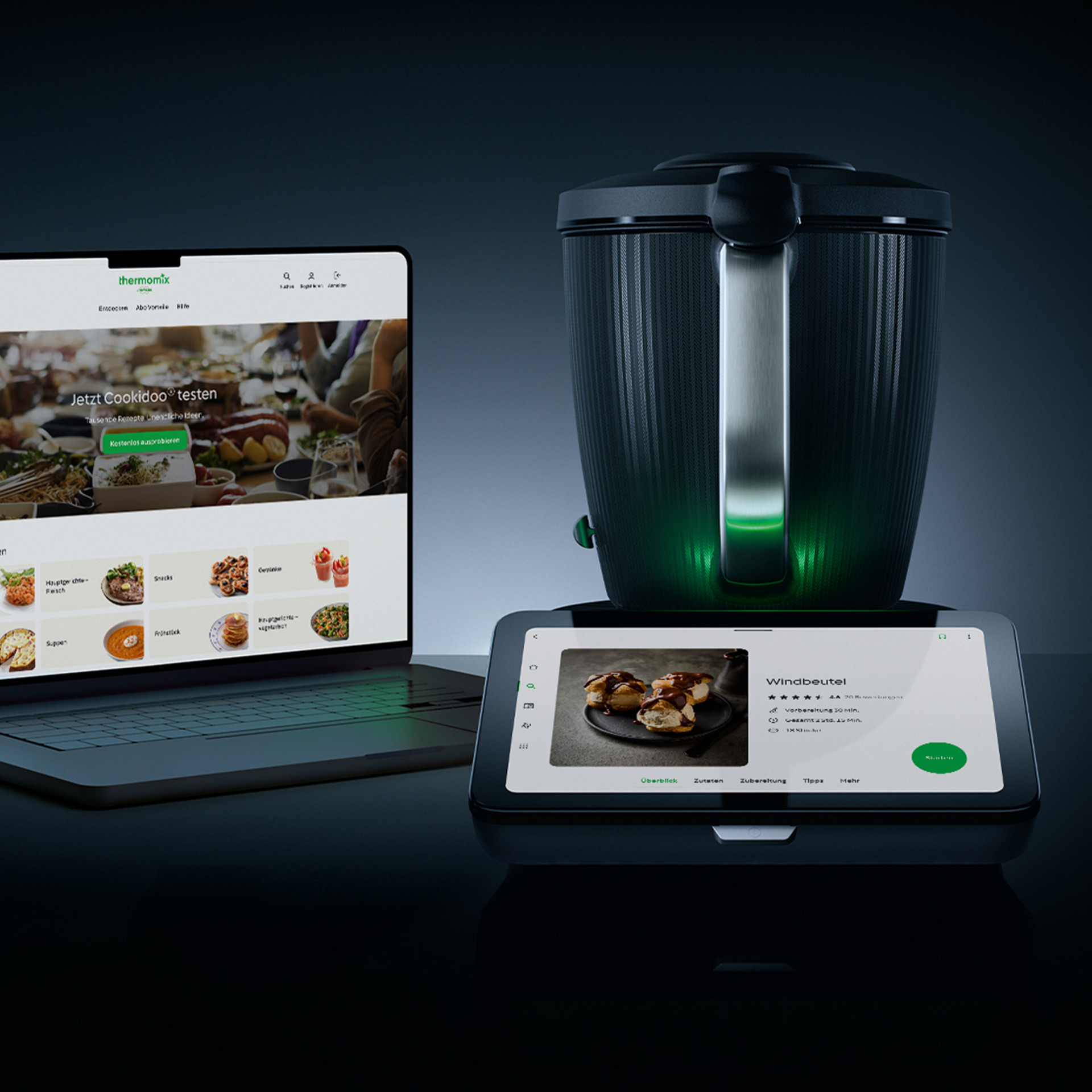 Thermomix® TM7 neben Laptop und Smartphone mit Cookidoo® Rezeptplattform-Benutzeroberfläche.