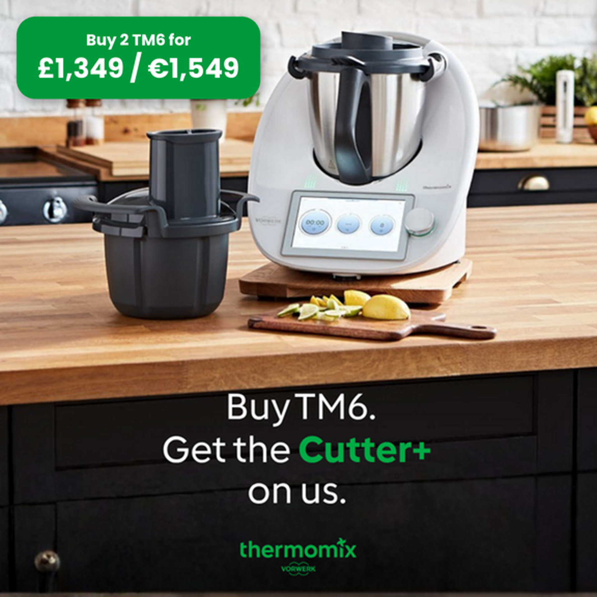 Thermomix® TM6 and Thermomix® Cutter Plus on a kitchen counter, wooden board with sliced apple and lemon in front.