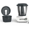 Thermomix Friend with mixing bowl simmering basket lid measuring cup and spatula arranged on a white surface