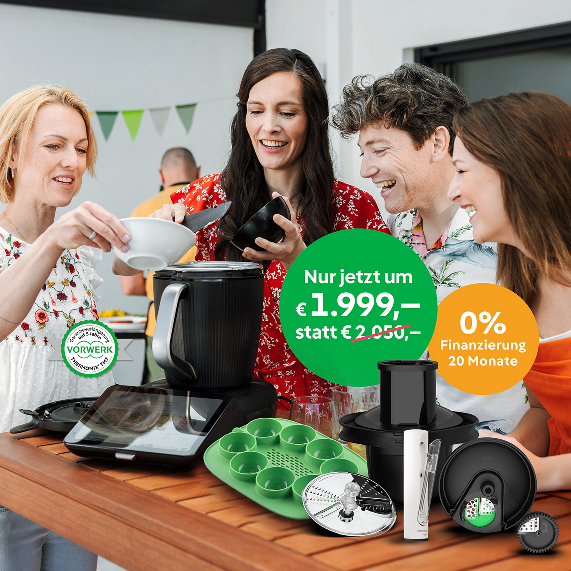 Vier Personen kochen gemeinsam mit dem Thermomix® TM7 und Zubehör; 0 % Finanzierung wird hervorgehoben.