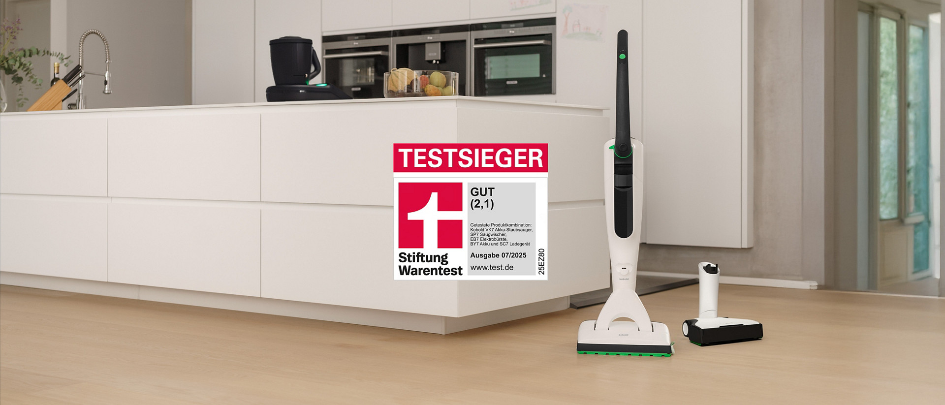 Kobold VK7 Akku-Staubsauger mit SP7 Saugwischer und EB7 Elektrobürste auf Küchenboden, Thermomix® TM7 steht auf der Arbeitsplatte, Stiftung Warentest Auszeichnung.