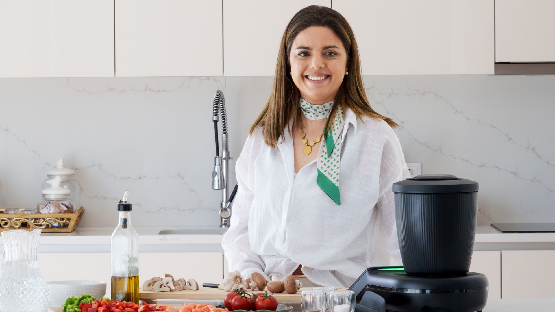 Mulher a preparar legumes numa cozinha com Bimby® TM7 à sua frente.