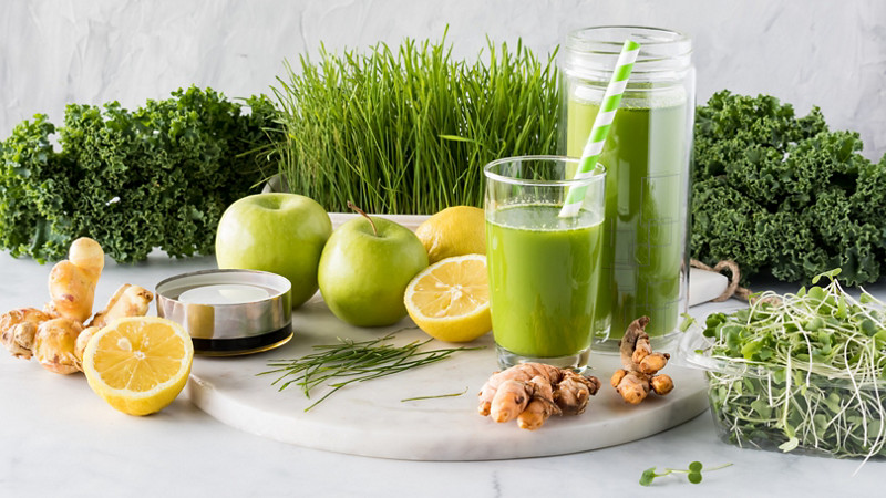 Narrow close up view of a collection of ingredients used to make a healthy green juice. 