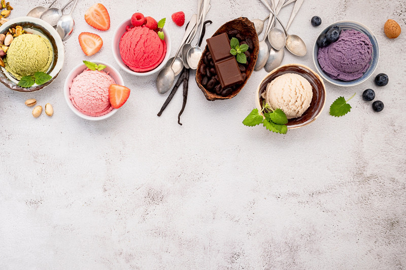 Various of ice cream  flavours in bowl blueberry ,green tea ,coconut ,strawberry and chocolate  setup on white stone background .