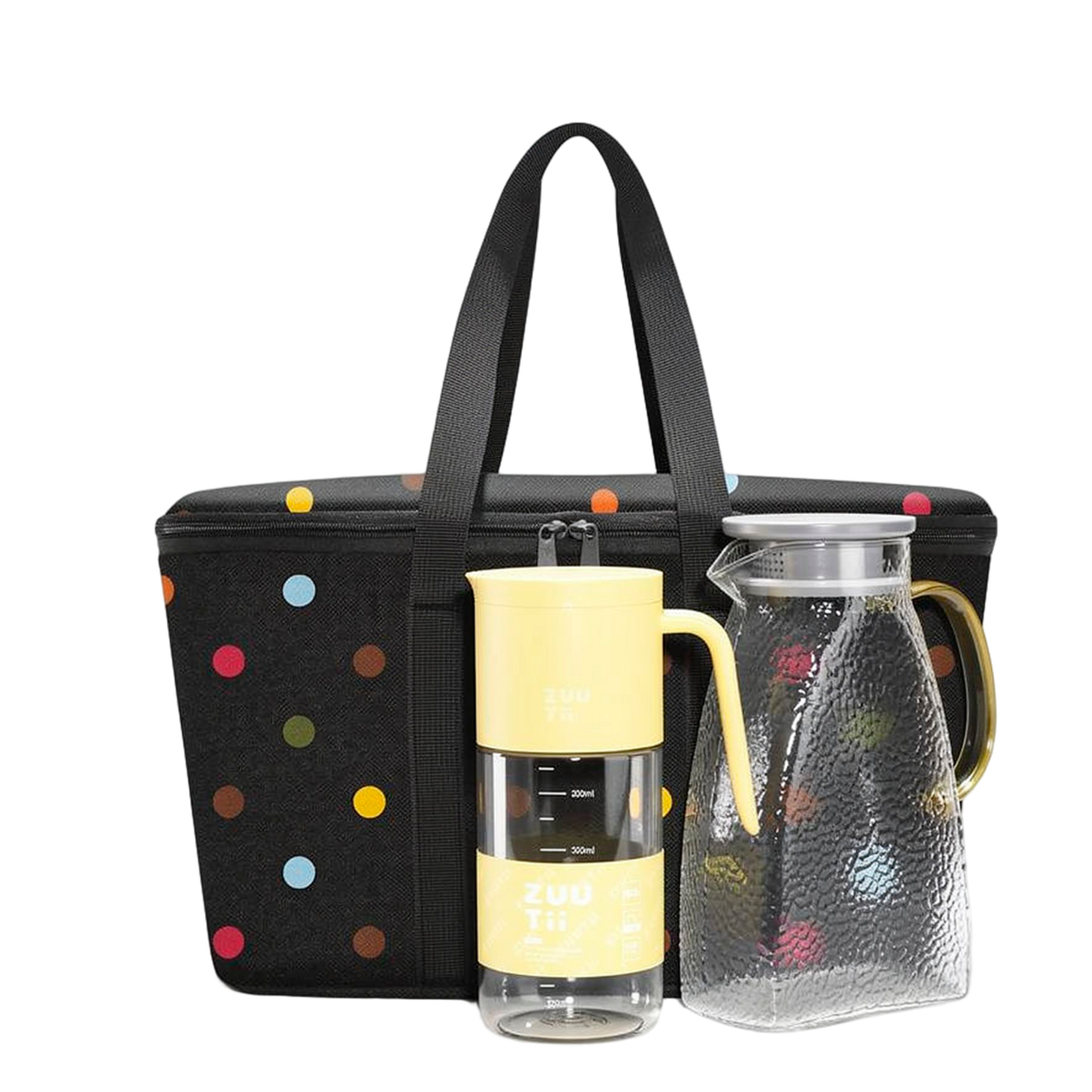 Bolsa negra con lunares de colores, taza de viaje amarilla y jarra de cristal con asa y tapa amarillas.