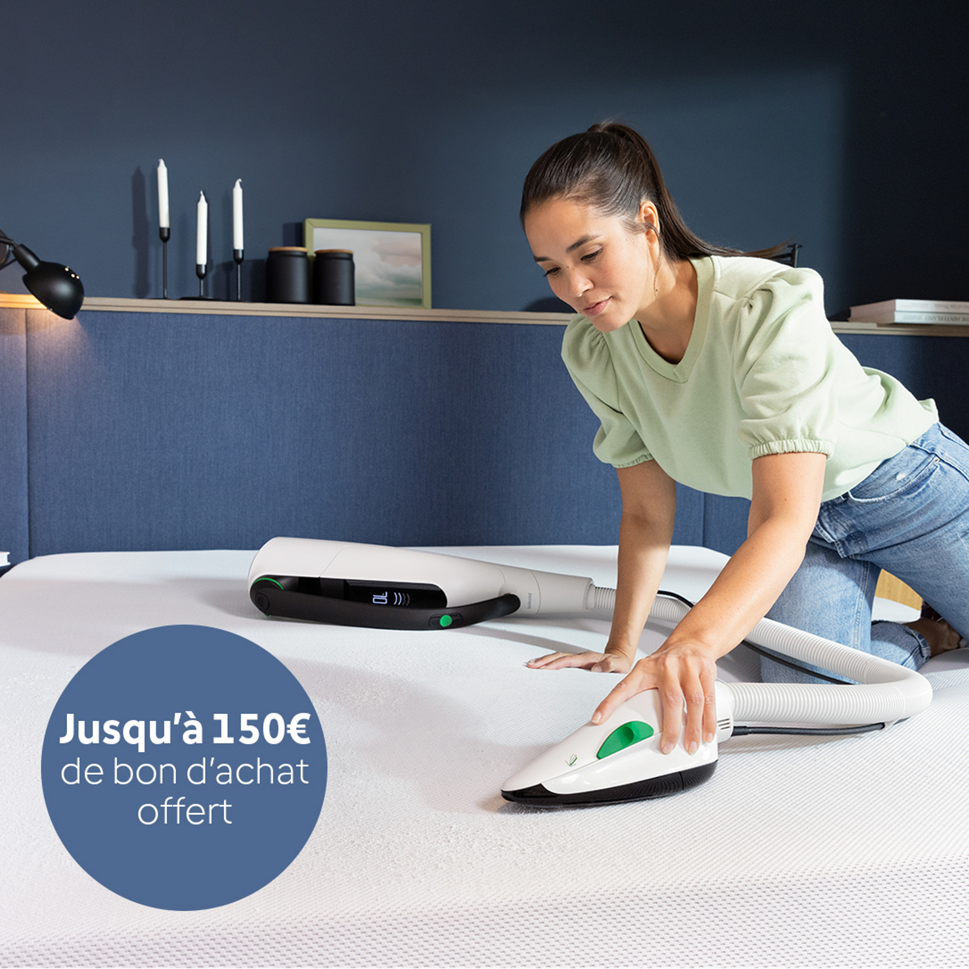 Femme nettoyant un matelas avec la Brosseur Textile Kobold PB7, fixée à un aspirateur sans fil Kobold VK7 dans une chambre moderne.