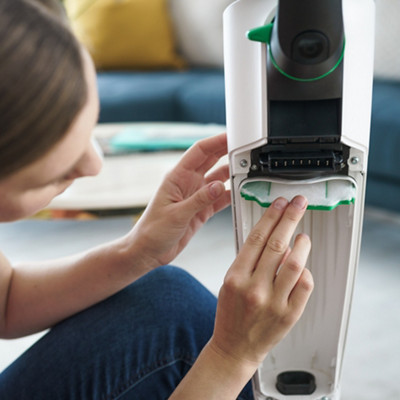 Une femme change le filtre de l'aspirateur sans fil VK7