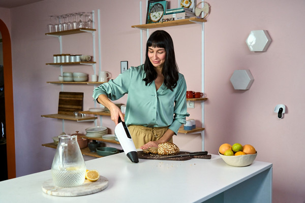 Femme utilisant l'aspirateur à main VM7