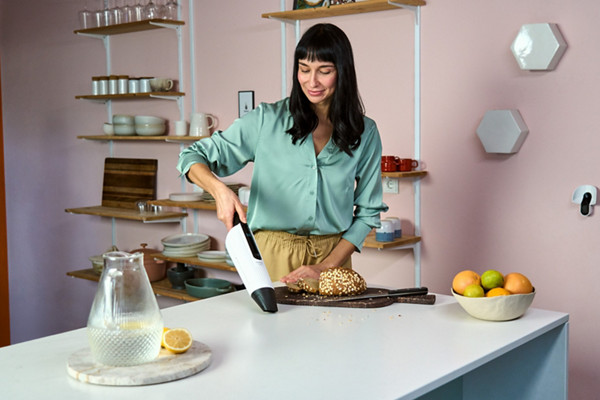 Femme utilisant l'aspirateur à main VM7