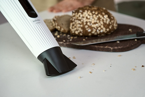 L'aspirateur de table VM7 aspire des miettes de pain sur une table