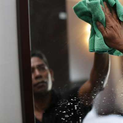 Une femme nettoie son miroir avec une lingette microfibre