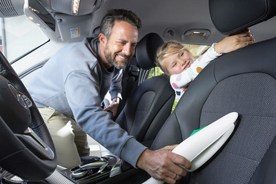Un père de sa famille passe l'aspirateur Kobold VK7 avec l'embout textile dans sa voiture