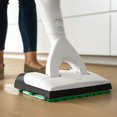 Un homme passe l'aspirateur laveur VK7 de chez Kobold sur son parquet avec de la terre.