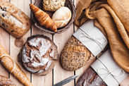 Delicious freshly baked bread on wooden background