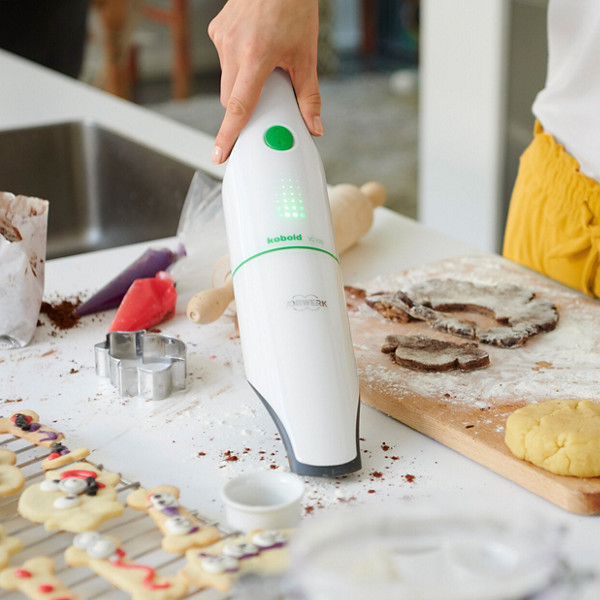 VC100 handheld vaccuum cleaner in use to clean clums from baking on kitchen counter