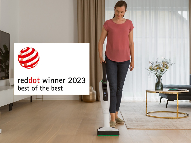 Frau saugt Parkett im Wohnzimmer mit VK7 und EB7. Auszeichnung reddot winner 2023 best of the best.