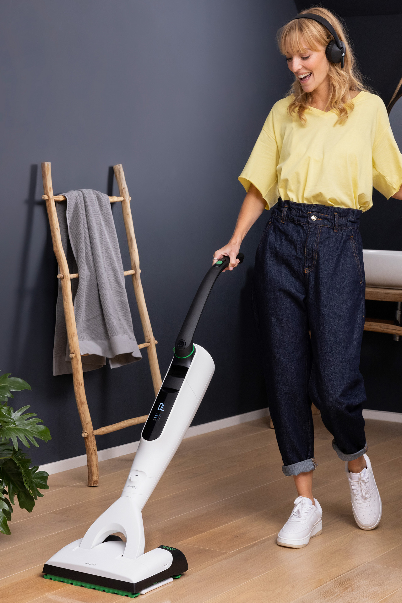 Person cleaning a bathroom floor with the Kobold VK7 in a modern home setting.