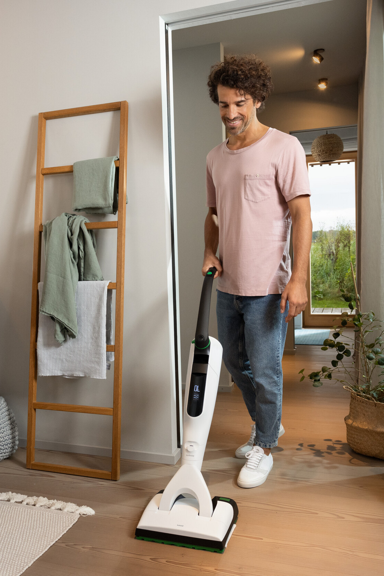 Person reinigt Holzboden zuhause mit VK7 Akku-Staubsauger SP7 Saugwischer.