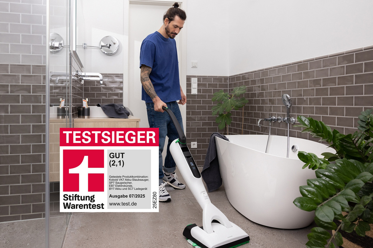Mann saugt mit VK7 Akku-Staubsauger in Badezimmre, Stiftung Warentest Siegel