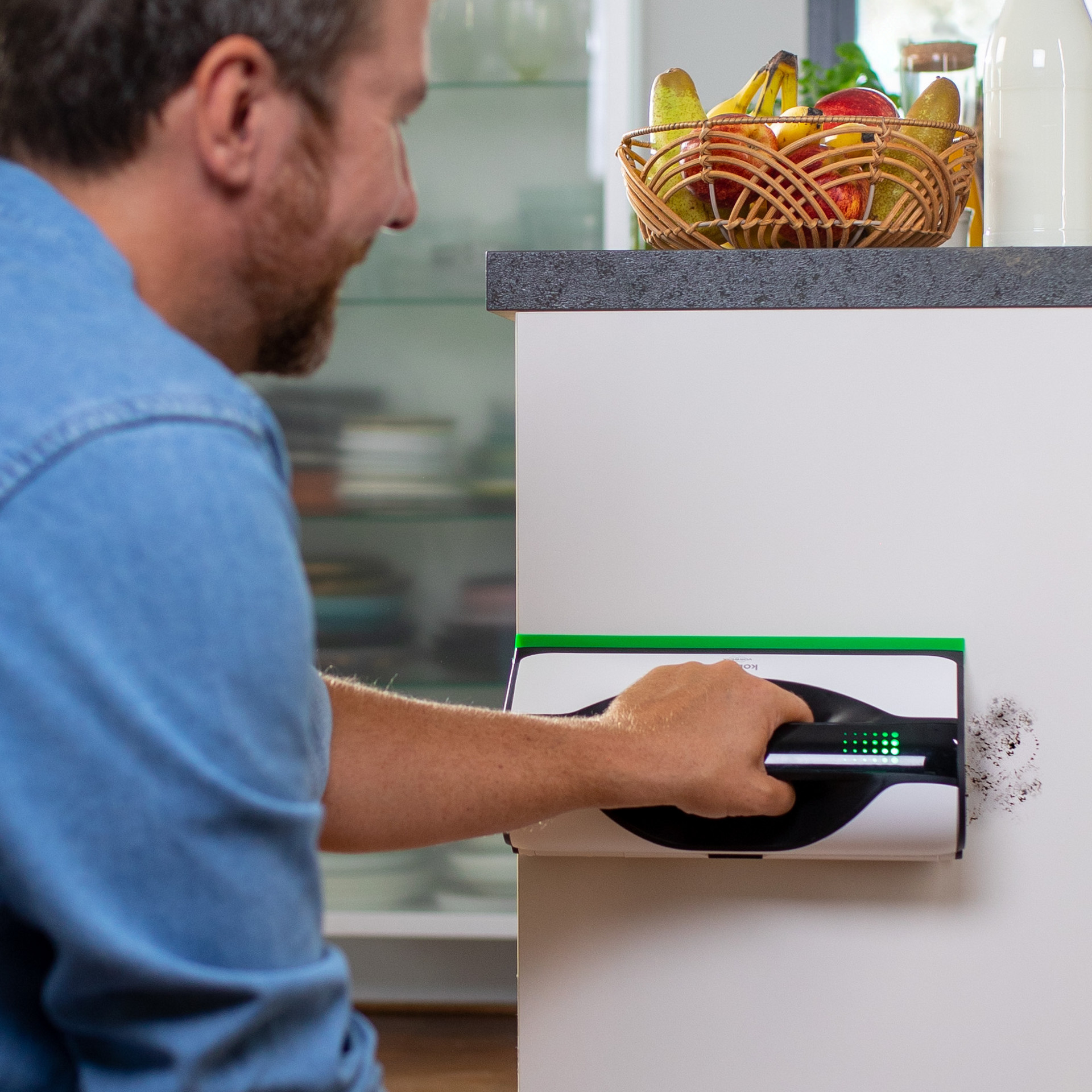 Personne nettoyant des taches sur le mur avec le nettoyeur de vitres Kobold VG100+ dans une cuisine.