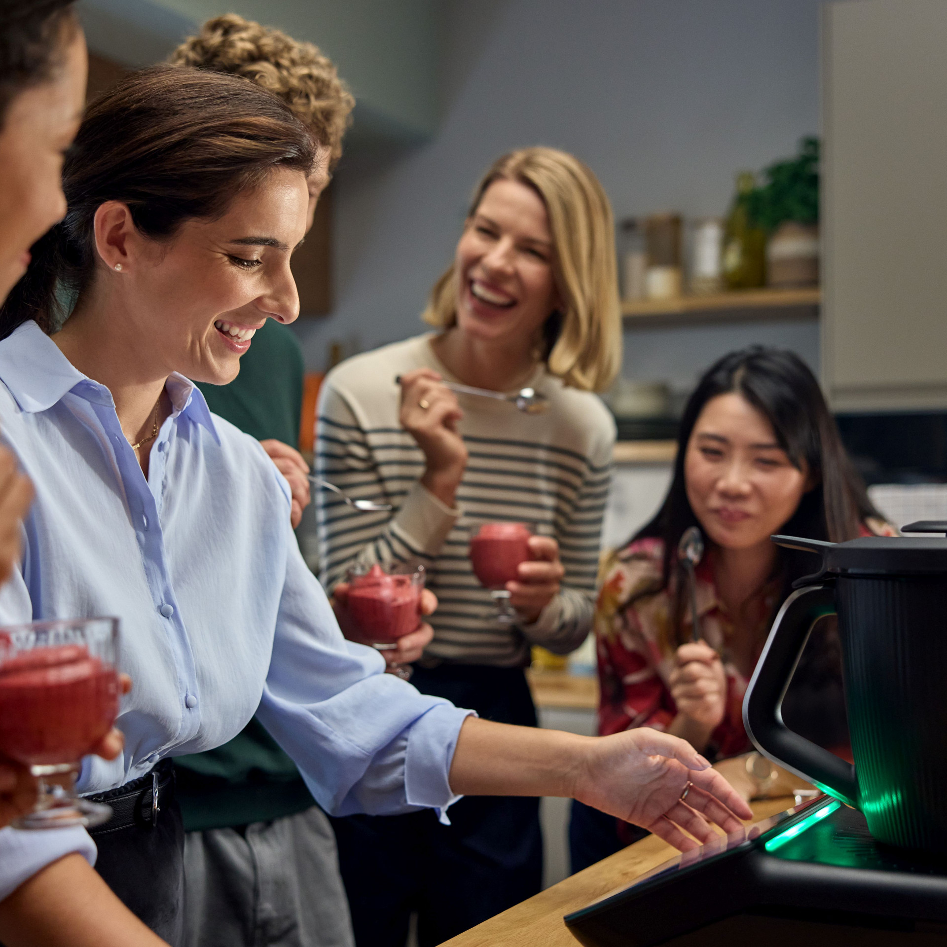 Group enjoying dessert near a Thermomix® TM7 on a kitchen counter.